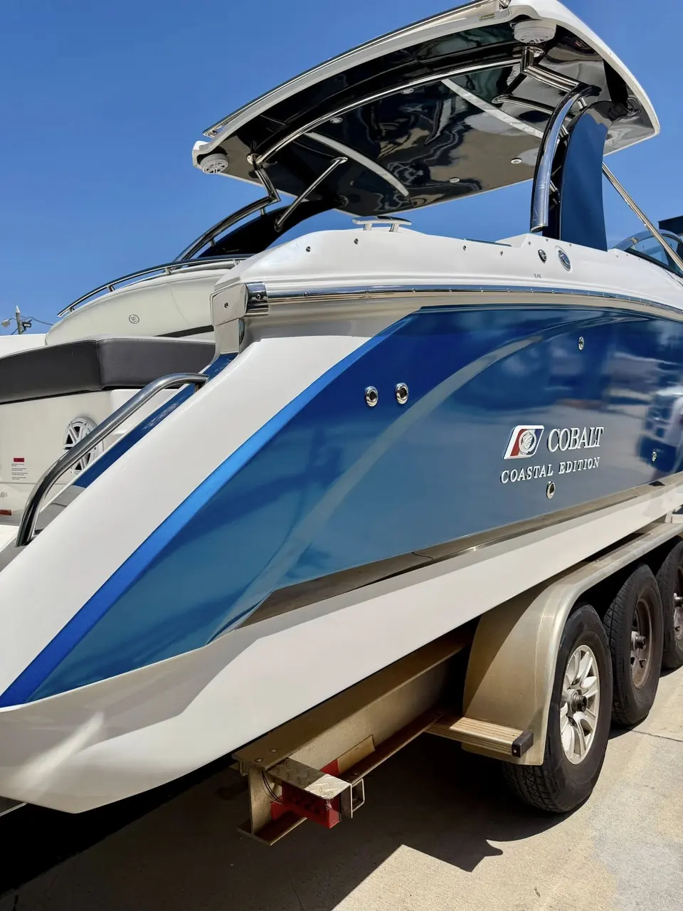 Cobalt bowrider with a gloss blue color-change wrap on its trailer