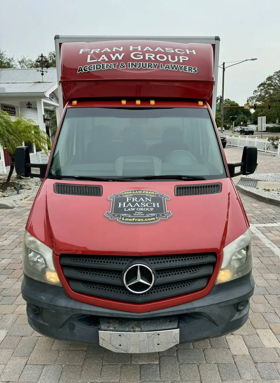 Front of a red box truck wrapped for a Palm Harbor law group