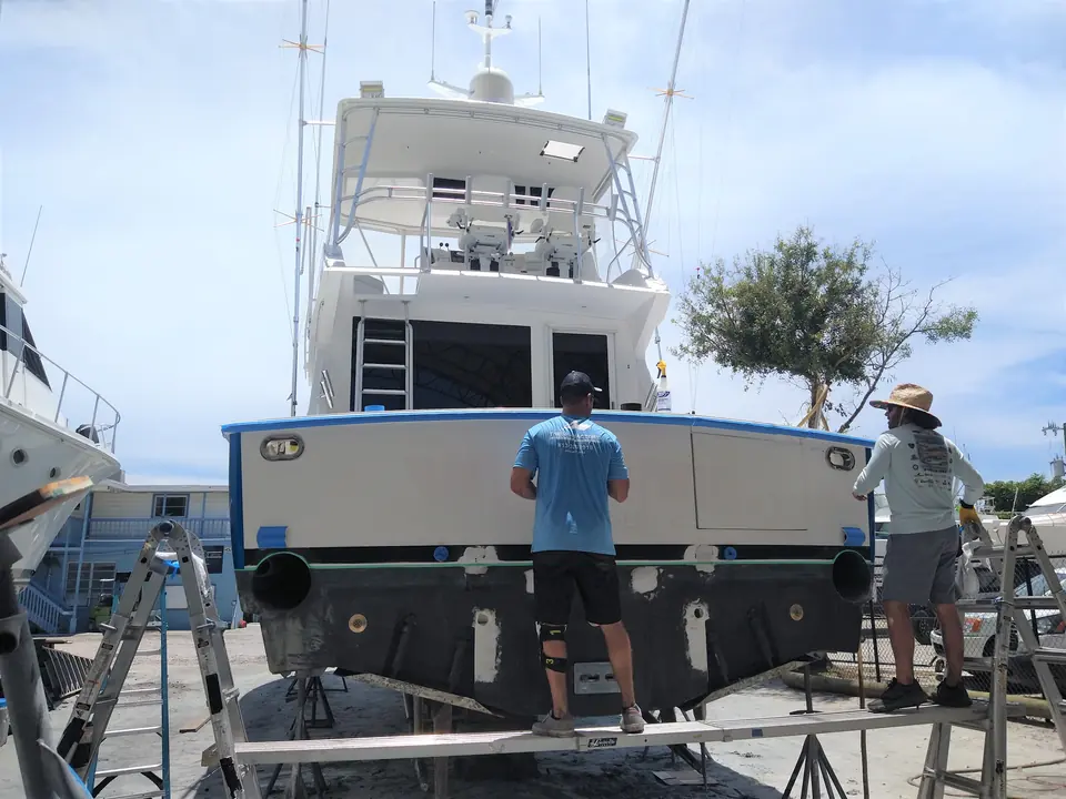 Crew preparing a sportfish transom before the wrap goes on