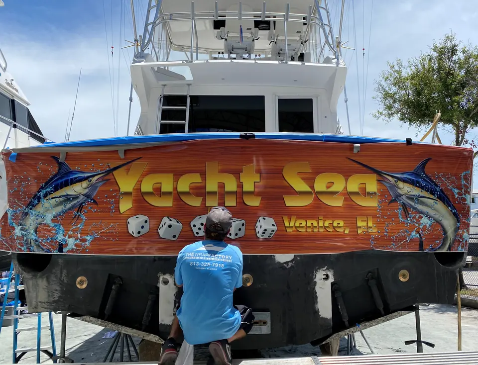 Yacht Sea transom wrap being installed on a sportfish on stands