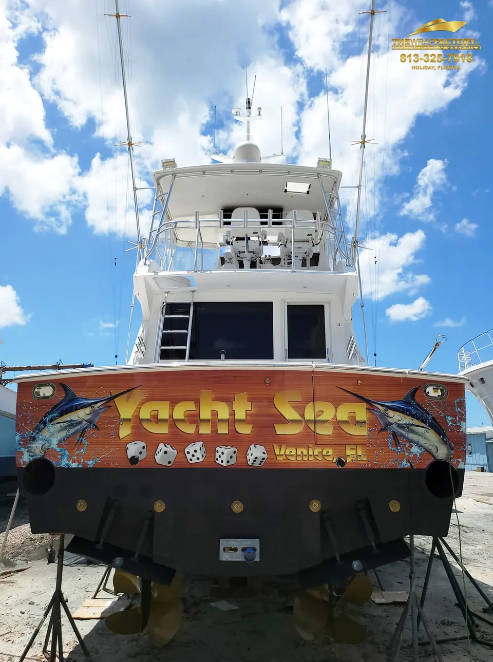 Finished Yacht Sea faux-teak transom wrap on a sportfish under blue sky